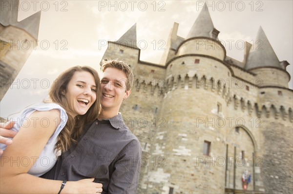 Caucasian couple smiling at castle