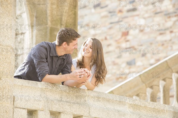 Caucasian couple leaning on balcony
