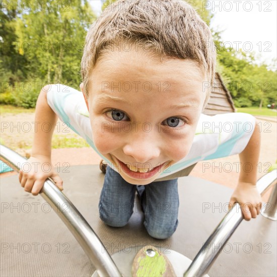 Caucasian boy playing on merry-go-round