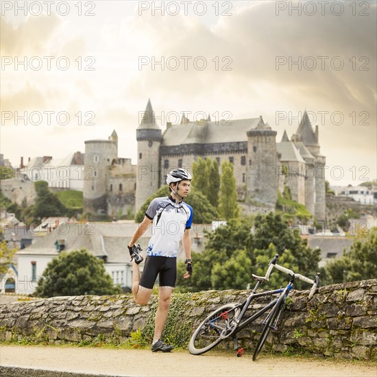 Caucasian cyclist stretching outdoors