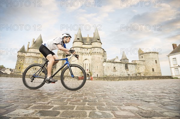 Caucasian man cycling near castle