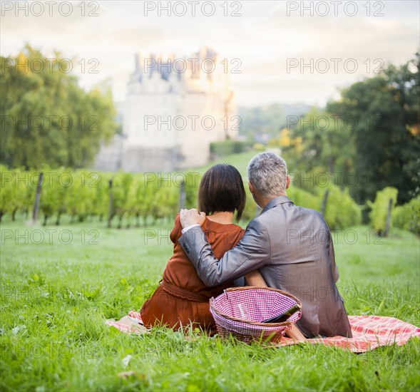 Caucasian couple enjoying picnic in vineyard