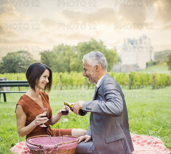 Caucasian couple enjoying wine at picnic