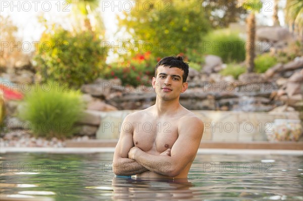 Hispanic man standing in swimming pool