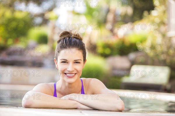 Caucasian woman smiling in swimming pool