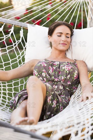 Caucasian woman laying in hammock