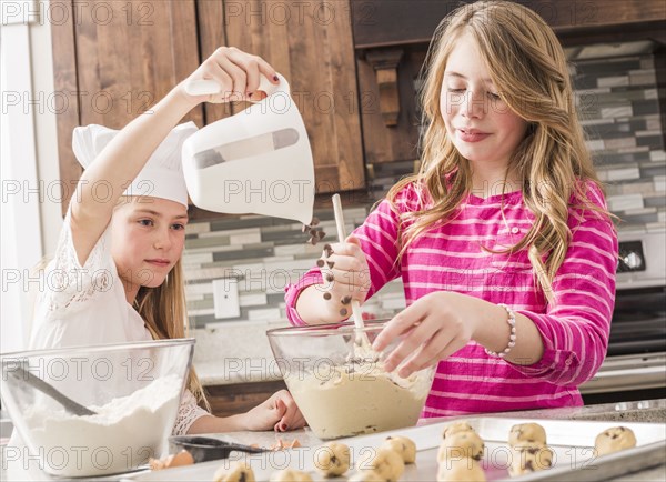 Caucasian girls baking in kitchen