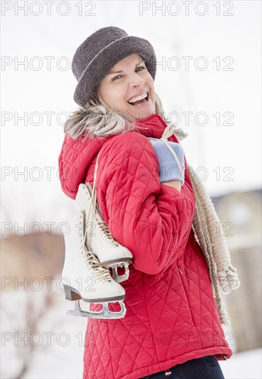Caucasian woman carrying ice skates outdoors