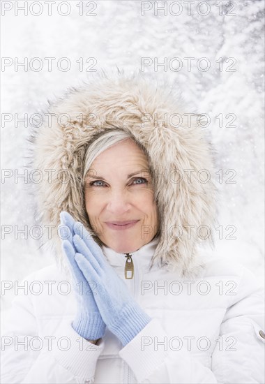 Caucasian woman wearing fur hood in snow