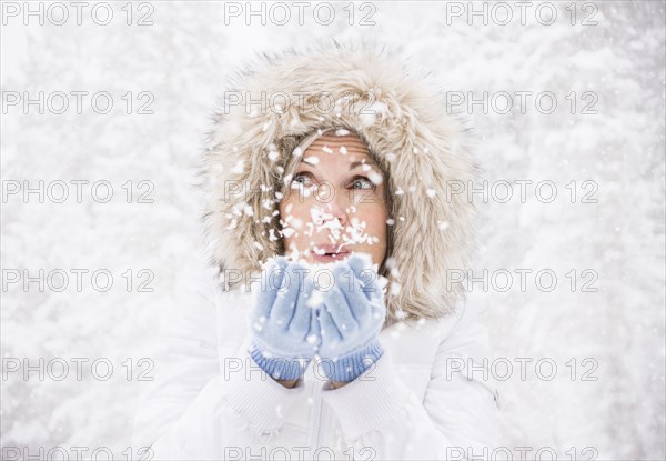 Caucasian woman playing in snow