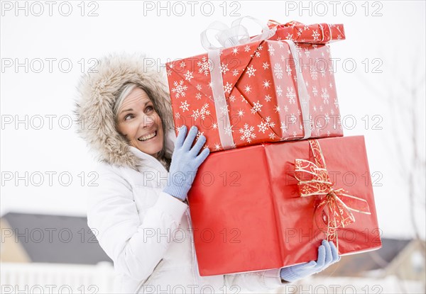 Caucasian woman carrying Christmas gifts