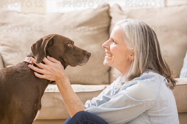 Caucasian woman hugging dog in living room