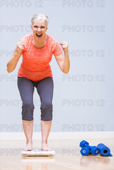 Caucasian woman cheering on scale