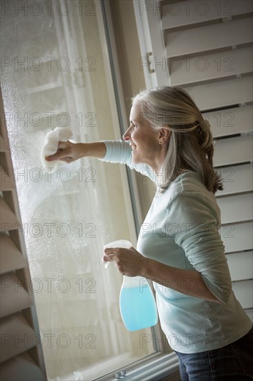 Caucasian woman washing window