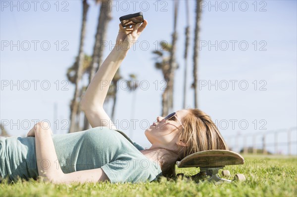 Caucasian woman using cell phone in park