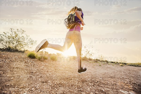 Caucasian woman running on remote hilltop