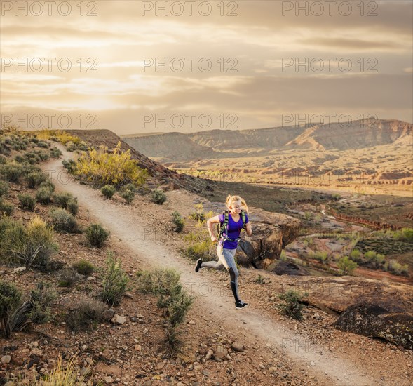 Caucasian woman running on remote dirt path