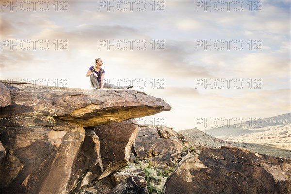 Caucasian woman stretching on rock formation