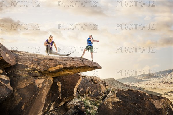 Caucasian couple stretching on rock formation