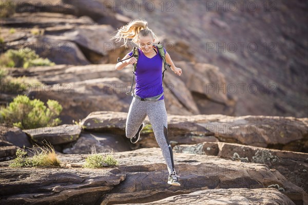 Caucasian woman running on rock formation