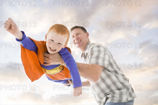 Caucasian father and son playing superhero