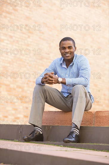 Smiling black man sitting on staircase