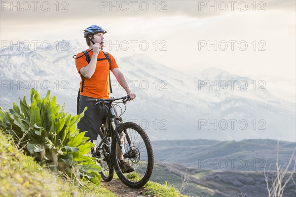 Caucasian man riding mountain bike resting and drinking water