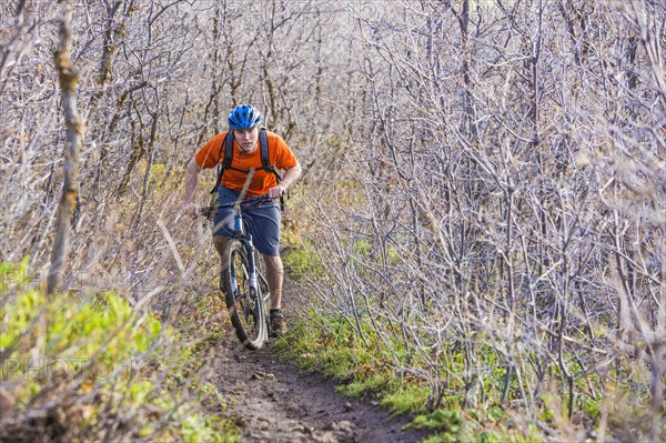 Caucasian man riding mountain bike in forest
