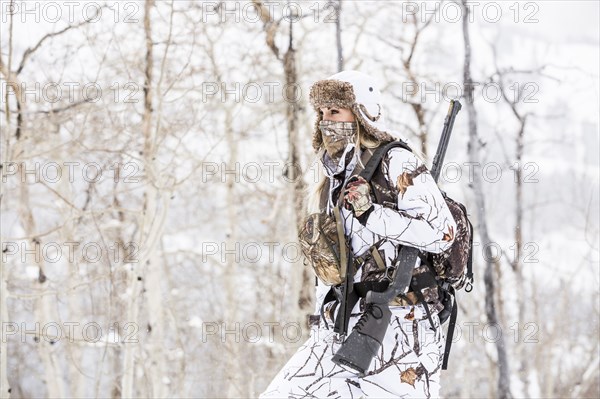 Caucasian woman hunting in forest wearing bandana