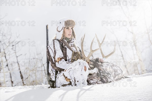 Caucasian woman hunting in forest holding antlers