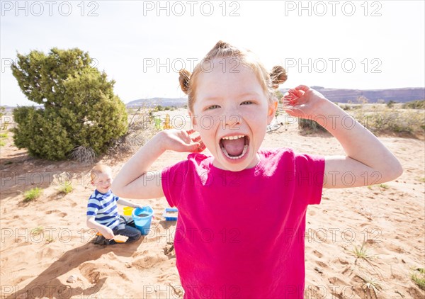 Caucasian girl screaming while camping with brother