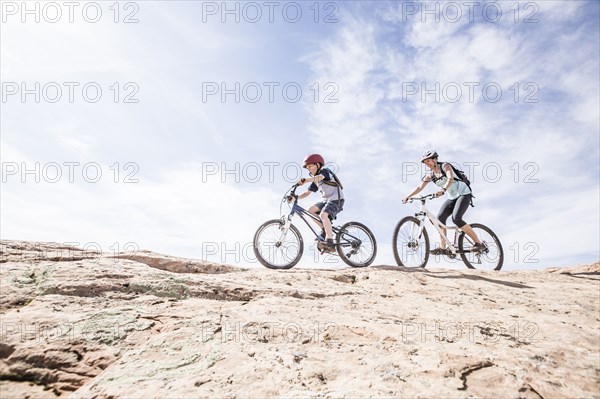 Caucasian mother and son riding mountain bikes