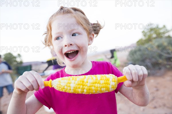 Caucasian girl eating corn on the cob