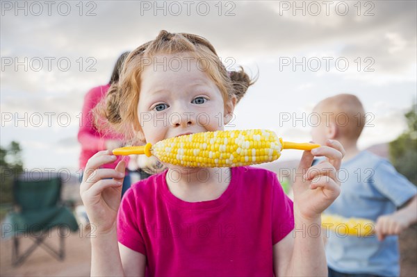 Caucasian girl eating corn on the cob