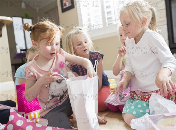 Caucasian girl opening gifts at party