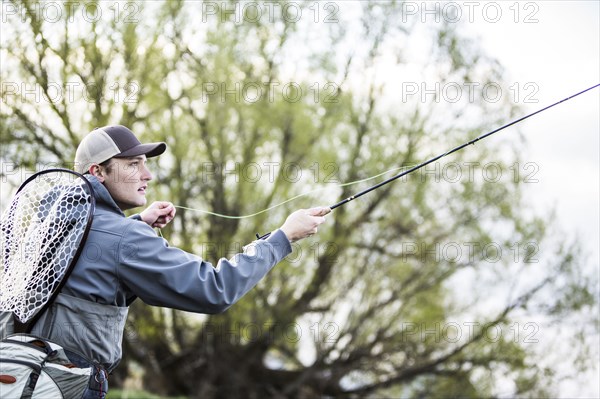 Caucasian man fly fishing