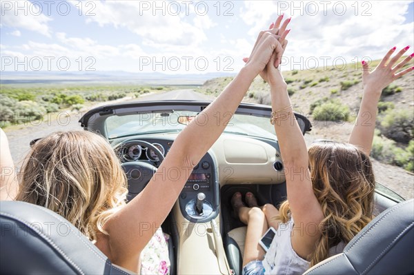 Caucasian women celebrating in sports car