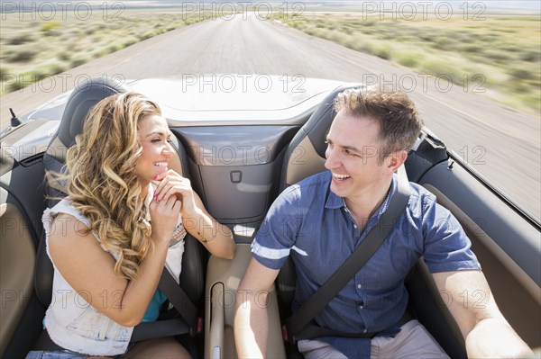 Caucasian couple driving in sports car