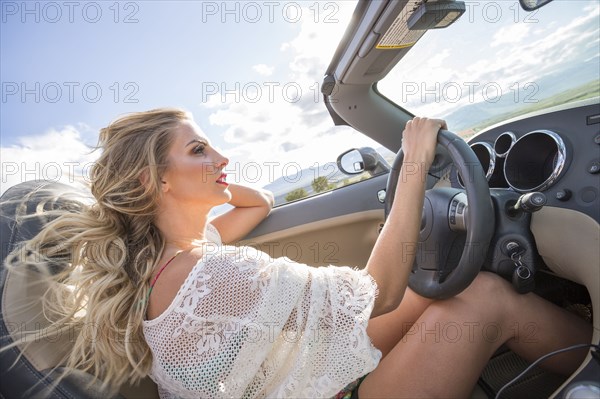 Caucasian woman driving in sports car