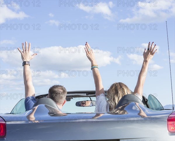Caucasian couple driving in sports car