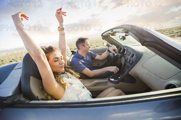 Caucasian couple driving in sports car