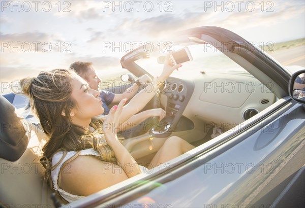 Caucasian couple driving in sports car