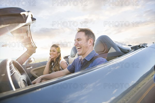 Caucasian couple driving in sports car