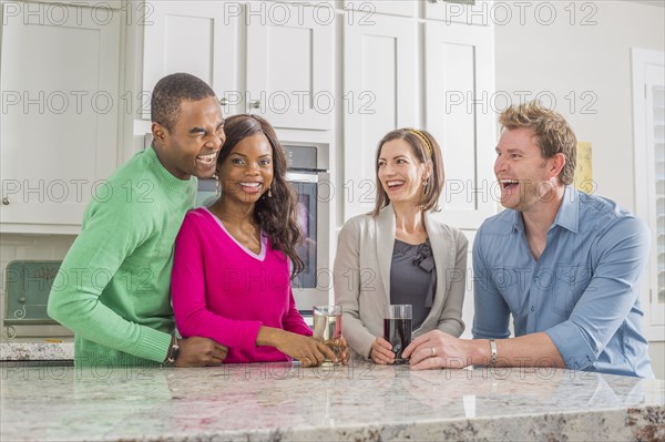 Friends laughing in kitchen