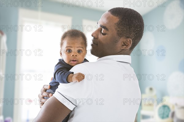 Black father holding baby son