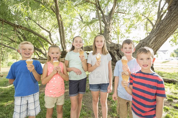 Caucasian boys and girls eating ice cream cones