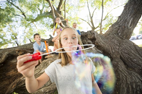 Caucasian girl making bubbles