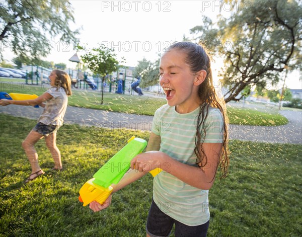 Wet Caucasian girls playing with squirt gun