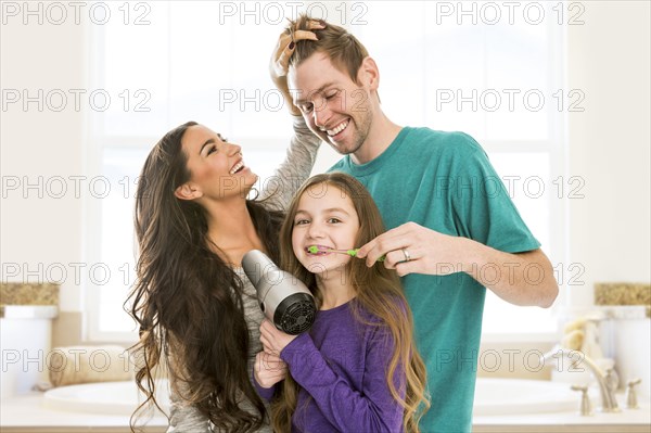 Family grooming each other in bathroom