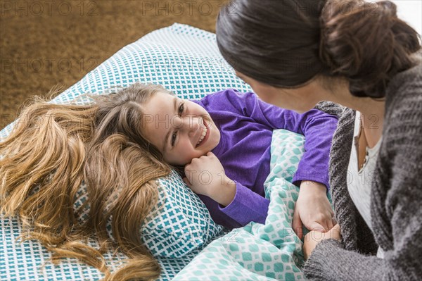 Mother comforting daughter at bedtime